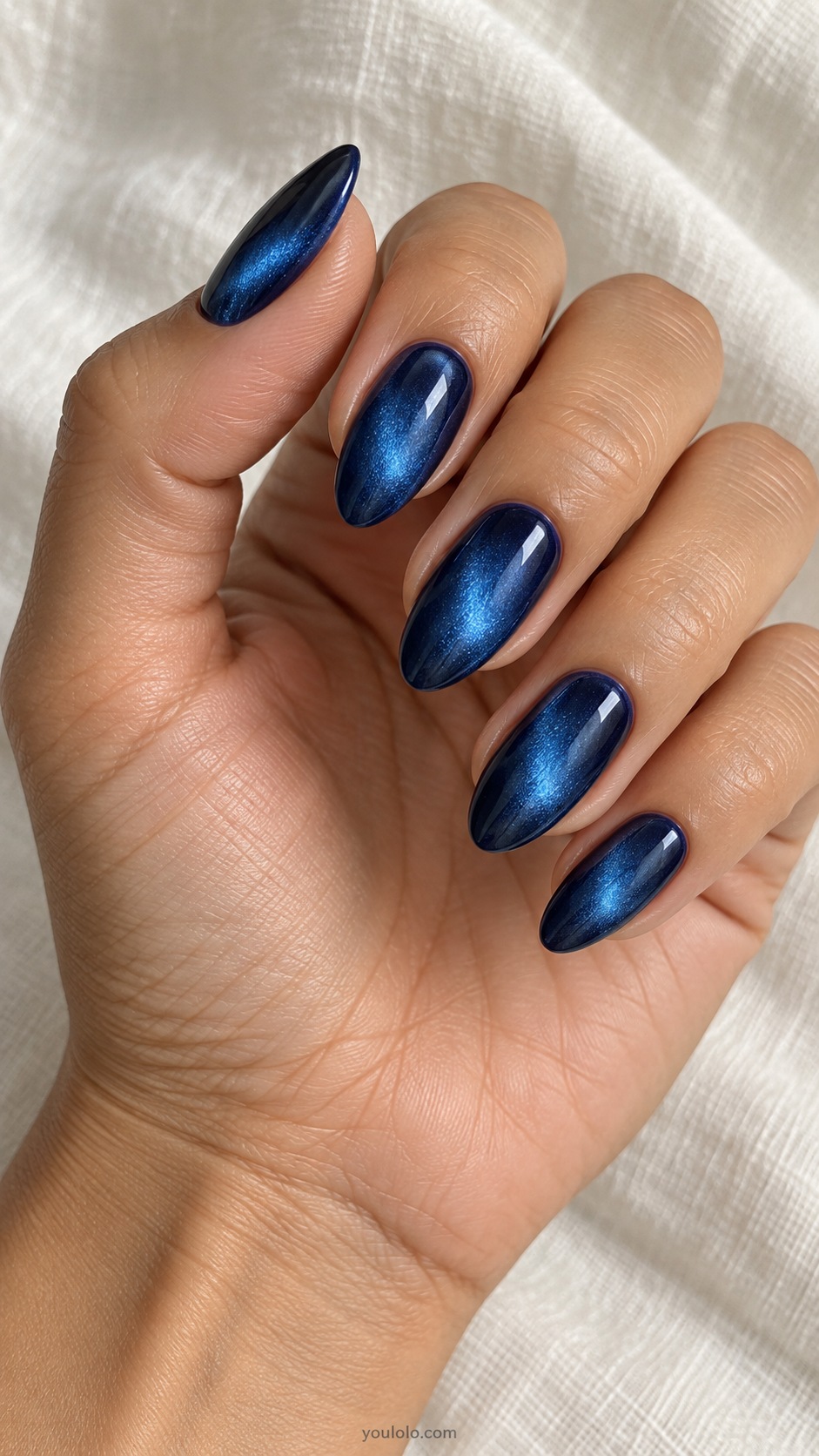 Sapphire Spotlight cat eye nails — Medium almond deep sapphire blue, concentrated oval magnetic blue glow in center dark edges.