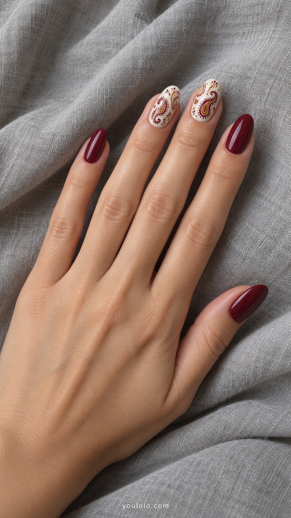 Medium almond nails ivory base flat tiny burgundy and ochre paisley pattern on middle and ring other nails burgundy