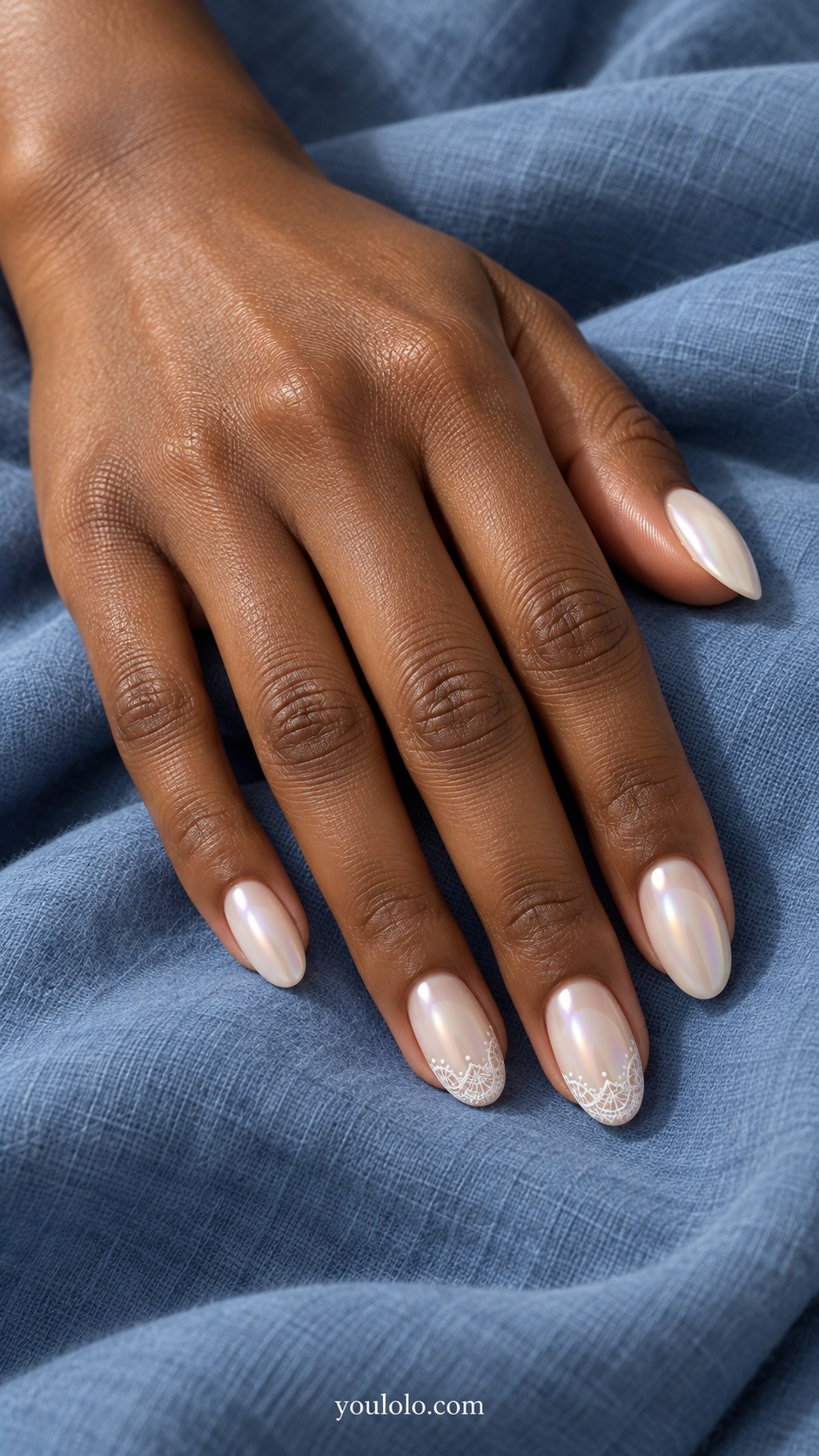 Medium oval nails pale ivory pearlescent glaze, middle and ring nails very fine flat white lace scallops at tips with tiny white dot detailing, other nails plain ivory pearl