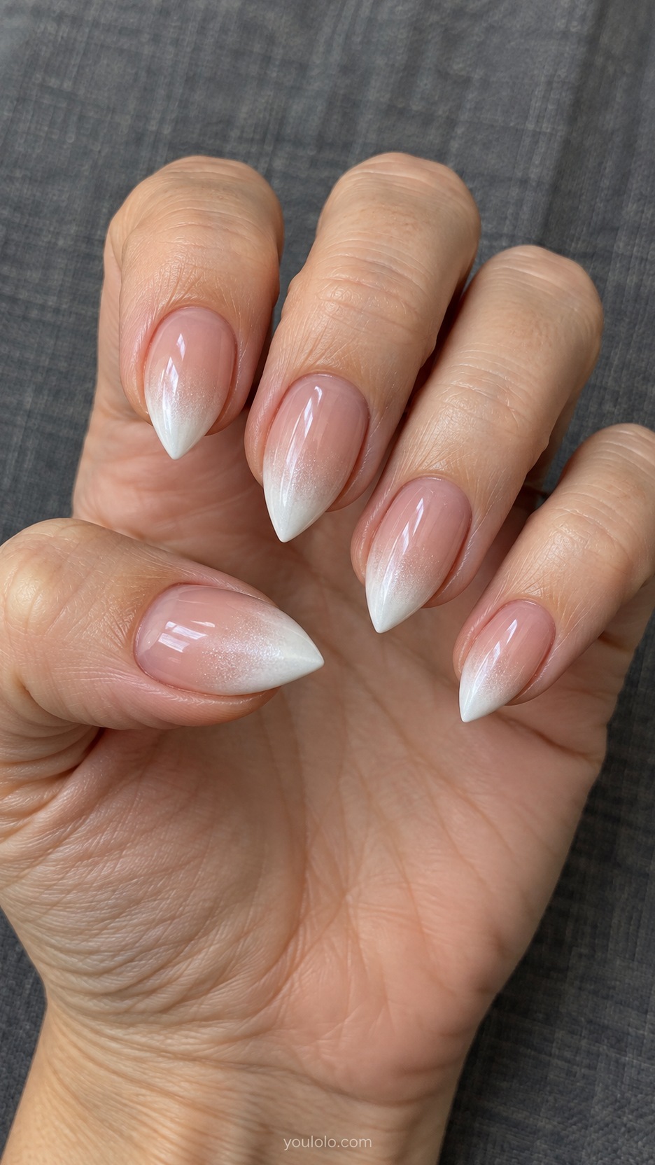Short Stiletto French Nails: Pearl White Fade Tips manicure on a naturally posed hand