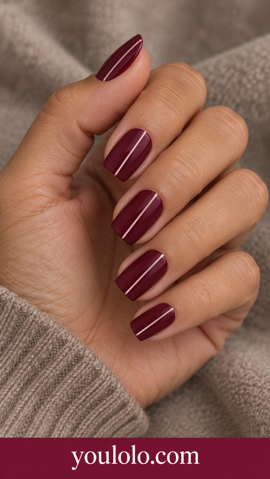 Wine Fine Pinstripe: medium square maroon nails one very thin soft pink vertical pinstripe off center on each nail on a naturally posed adult hand