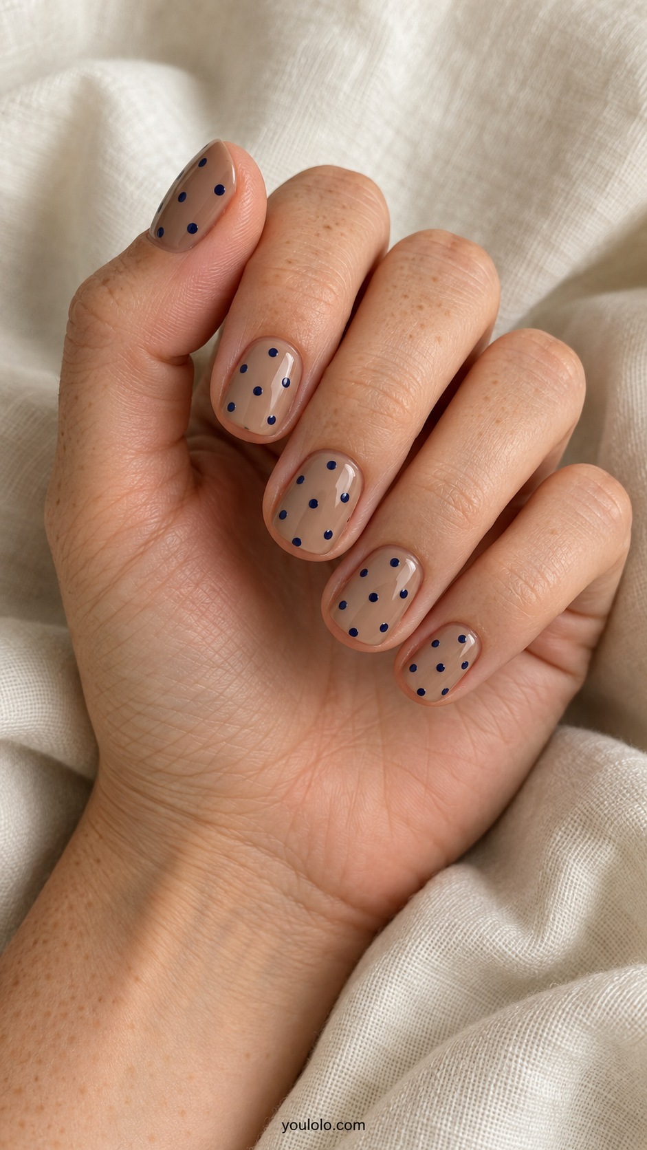 Short squoval nails light mocha base sparse medium navy polka dots evenly spaced