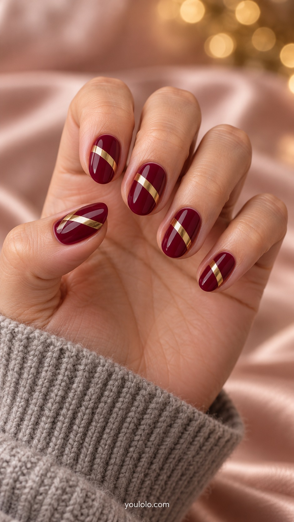 Short almond cranberry nails one slanted gold chrome transverse band crossing nail