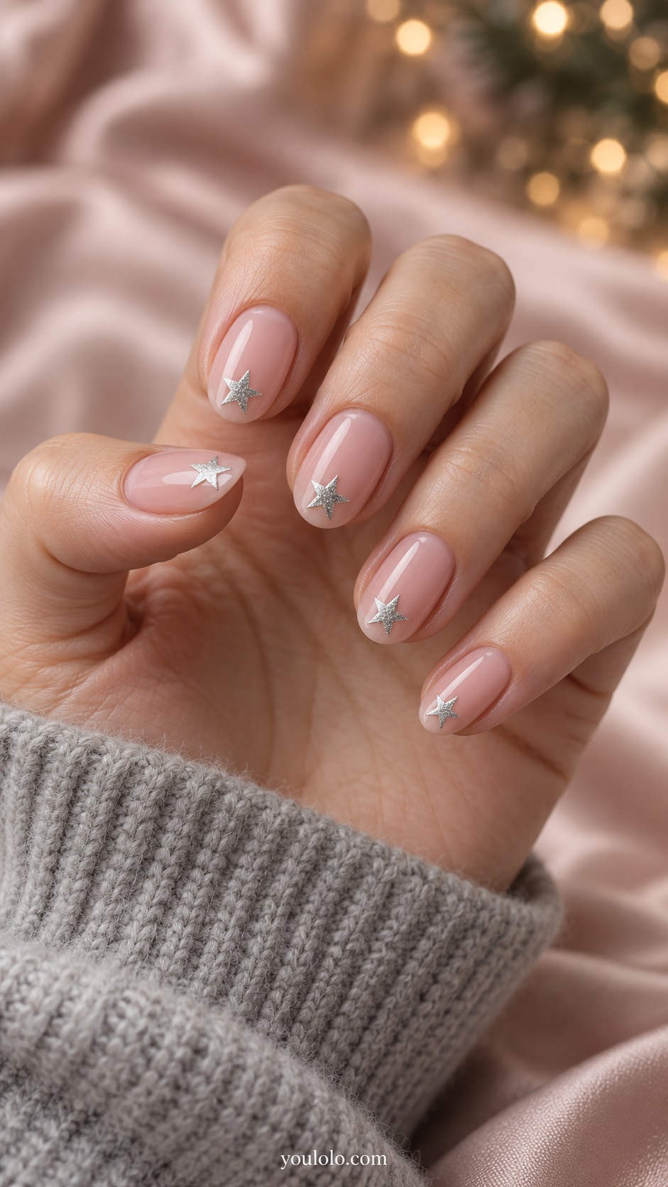 Short almond blush pink nails silver five pointed stars placed near tips leaving clear base