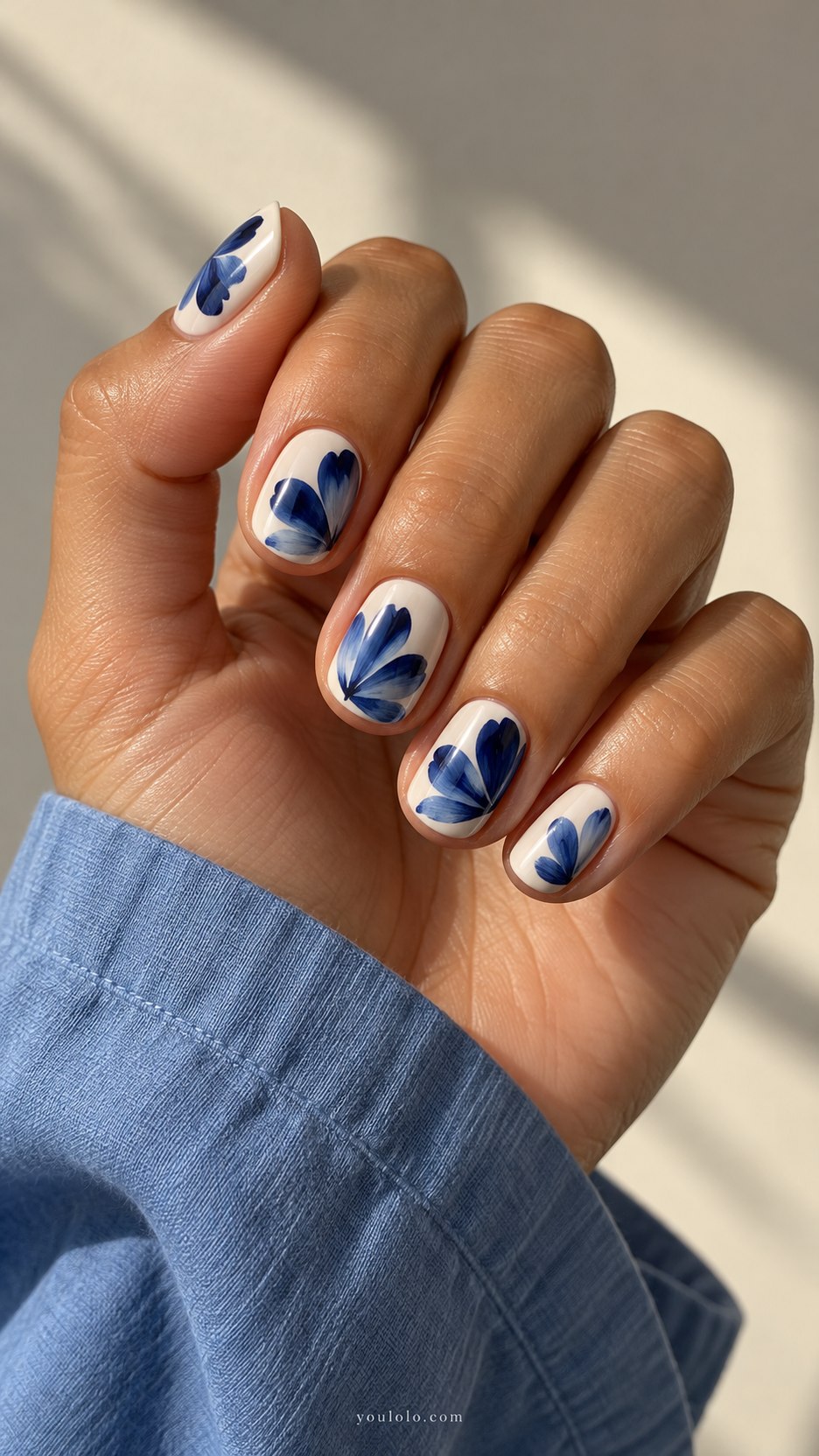 Indigo Brushstroke Petals: short rounded cream nails, bold single indigo brushstroke petals with white breathing room
