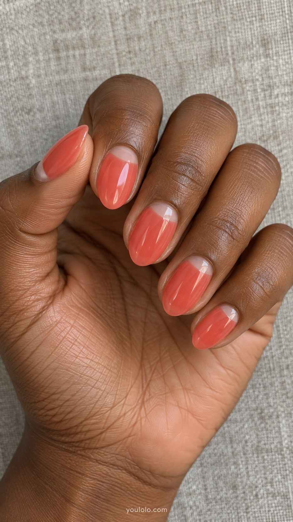 Short Almond Nail Designs: Coral Jelly Half Moons manicure on a naturally posed hand