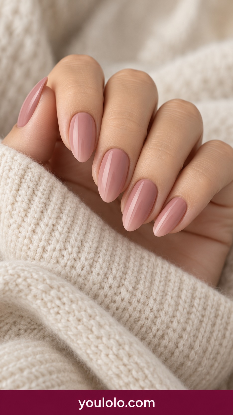 Short almond muted dusty blush nails smooth opaque cream finish plain on a naturally curled young adult hand