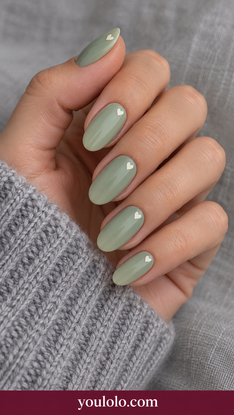 Heart Stamp Corner: medium oval sage cream nails one tiny ivory heart confined to upper outer corner on each nail on a naturally posed adult hand