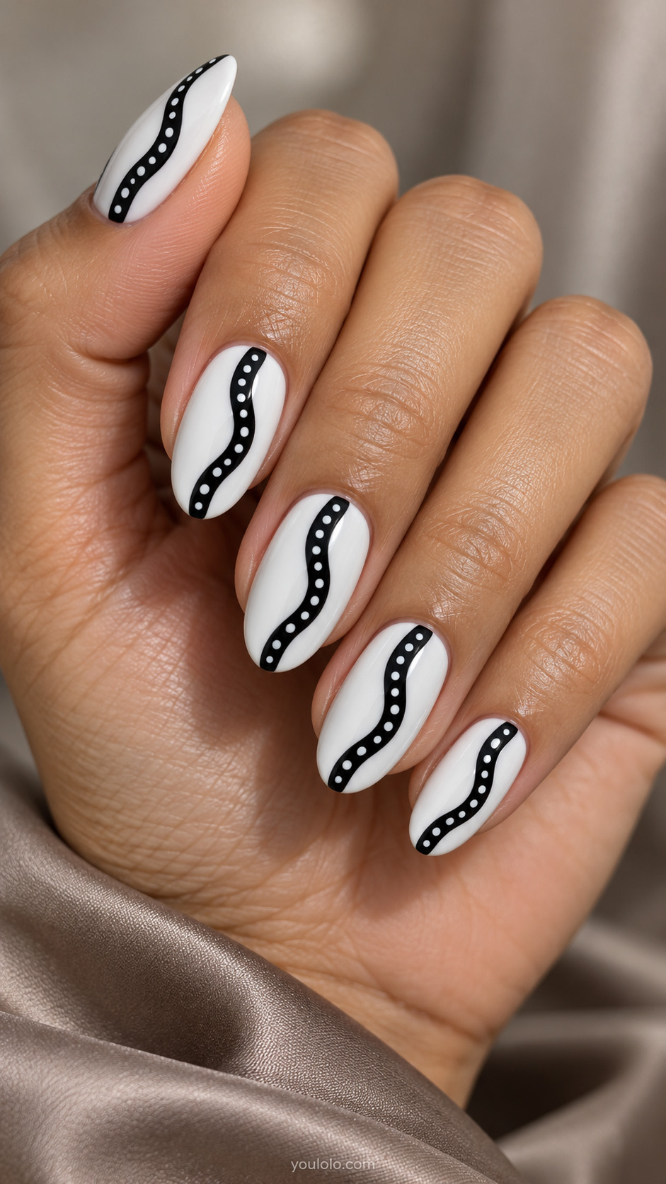 Medium oval white nails with black wavy ribbon running lengthwise center, ribbon filled with evenly spaced tiny white dots; white borders clear