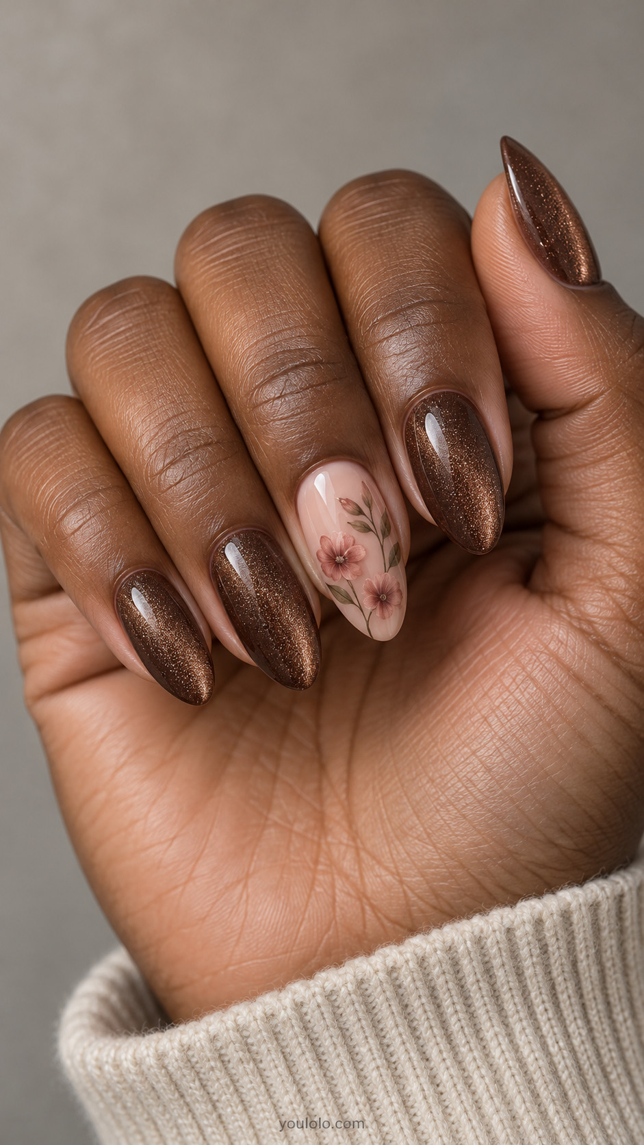 Almond walnut magnetic nails with two dusty pink blossoms on a sheer blush middle-finger accent.