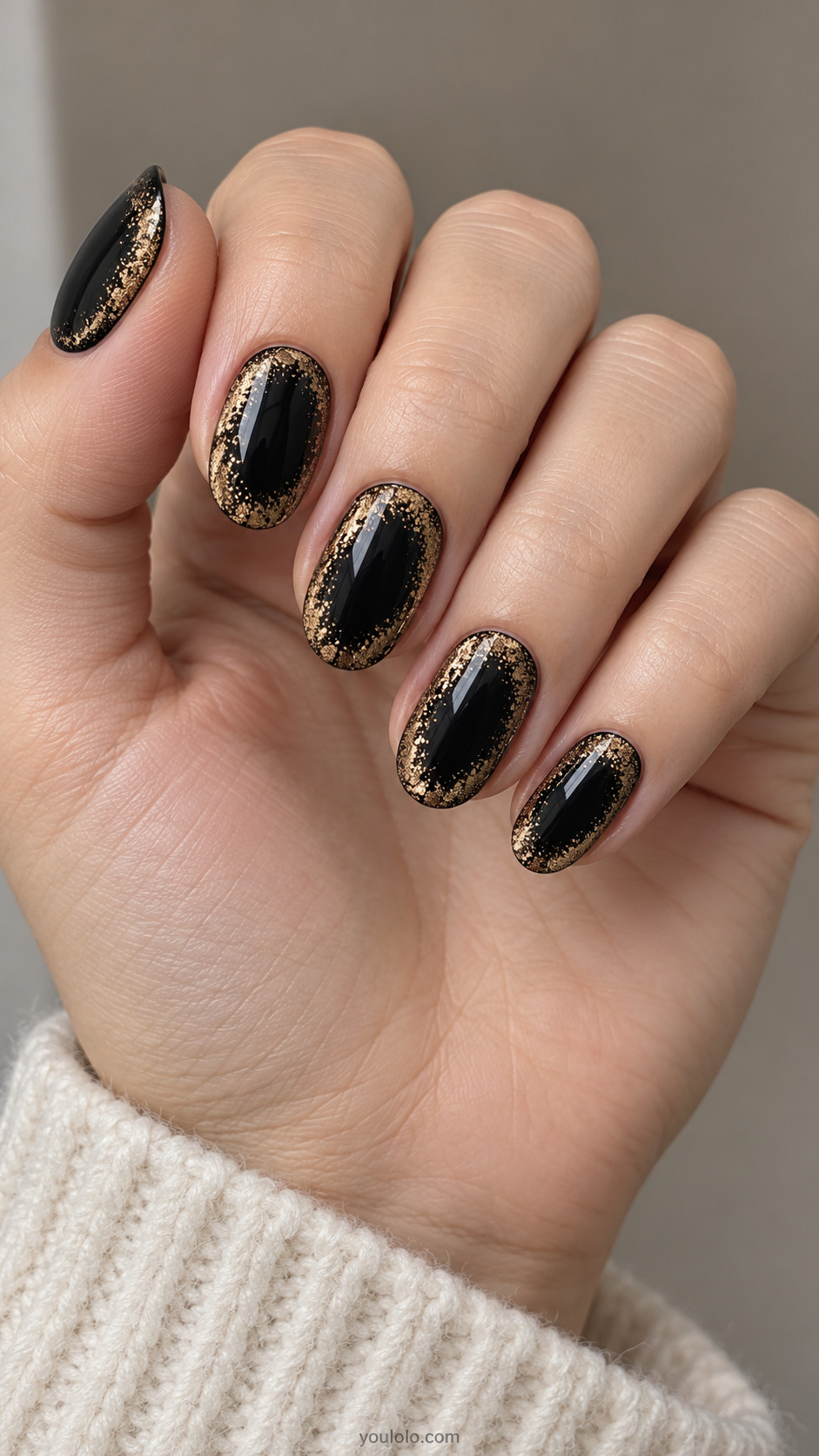 Rounded black nails with softly sponged gold halos around dark centers