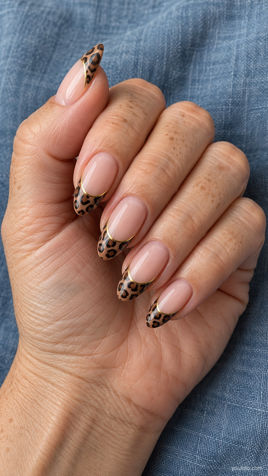 Long nude almond nails with brown leopard tips and a fine gold border