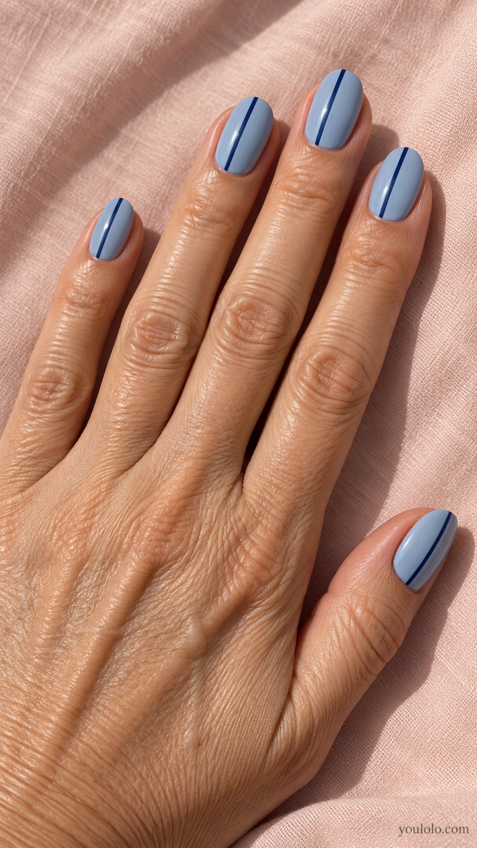 Medium oval nails dusty light blue cream with one thin darker denim vertical stripe offset on each nail