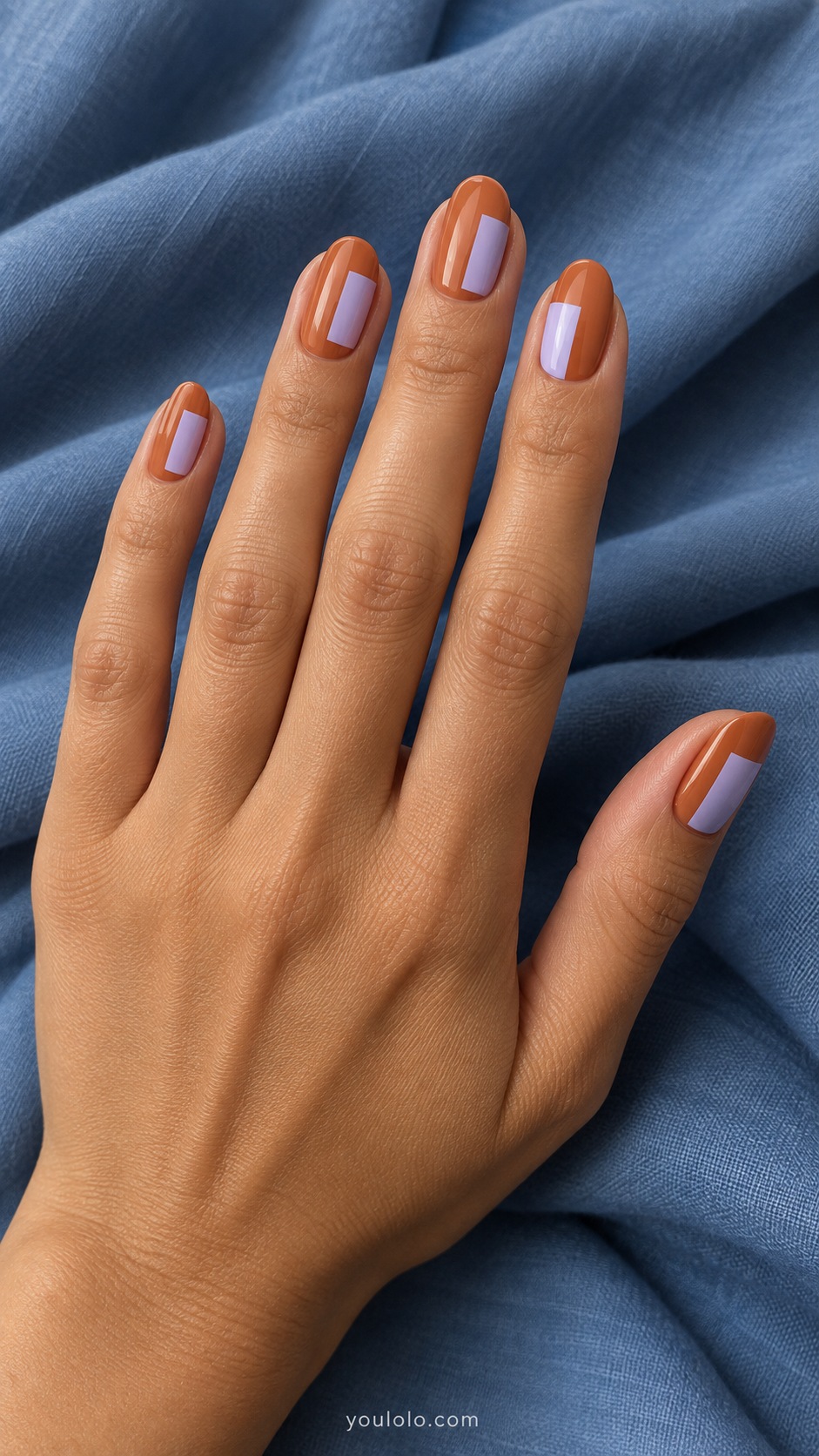 Medium oval nails muted clay orange with pale lilac rectangular panels offset on each nail