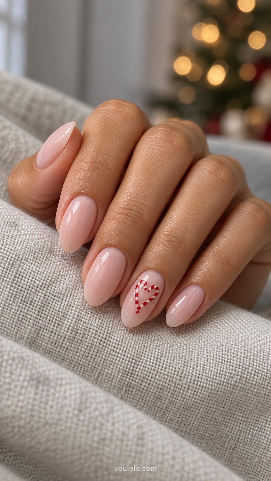 Medium almond milky pink nails one ring nail two small red white candy canes arranged heart shape