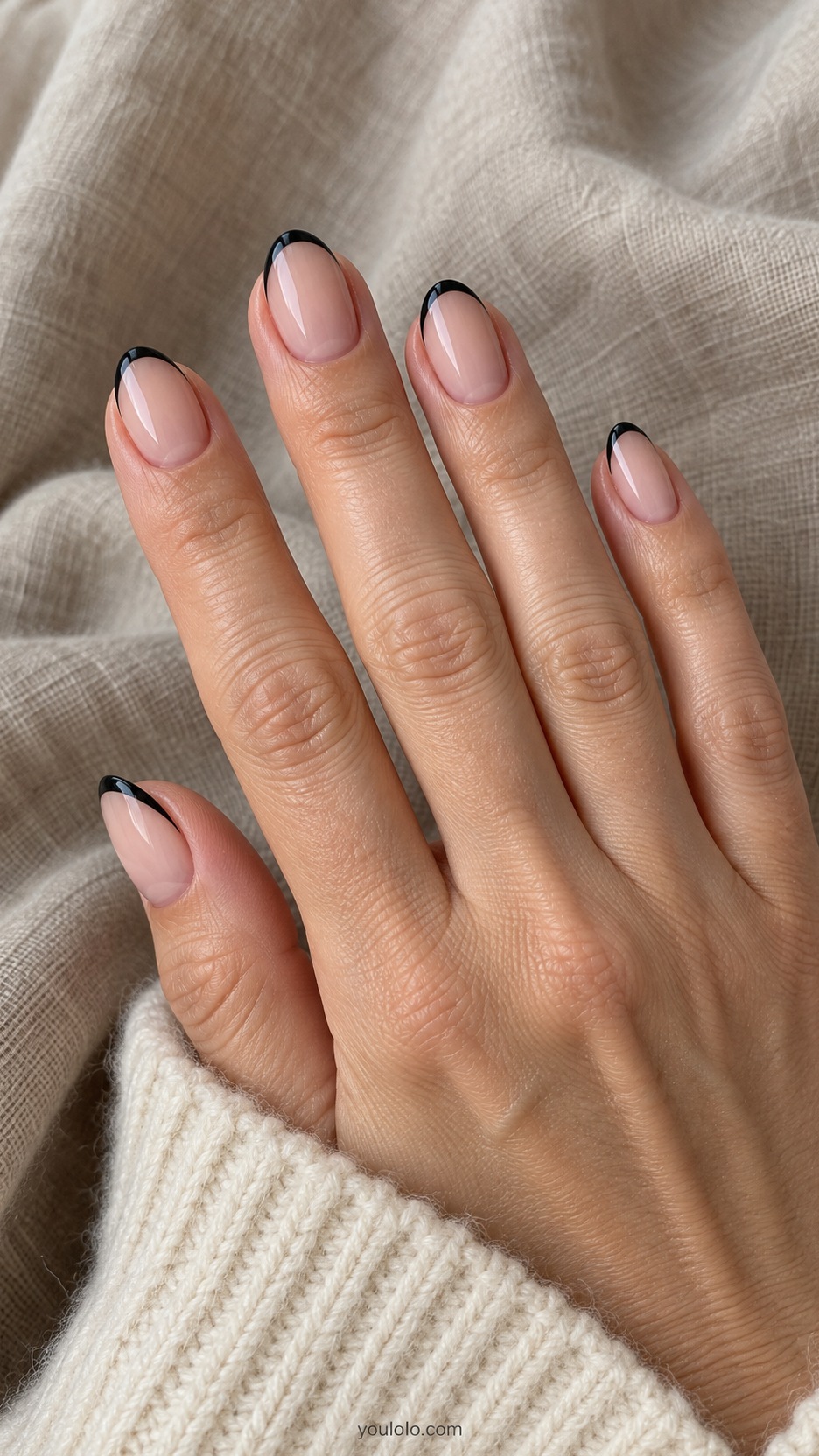 Short Almond Nail Designs: Black Fine-Line Tips manicure on a naturally posed hand