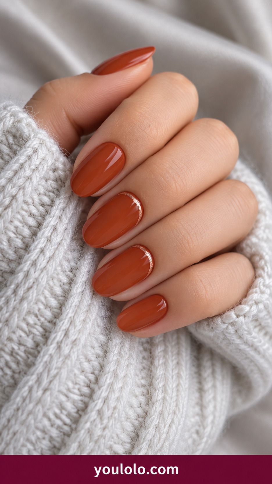 Short almond terracotta nails with very fine copper crescent near base on two accents on a naturally curled young adult hand