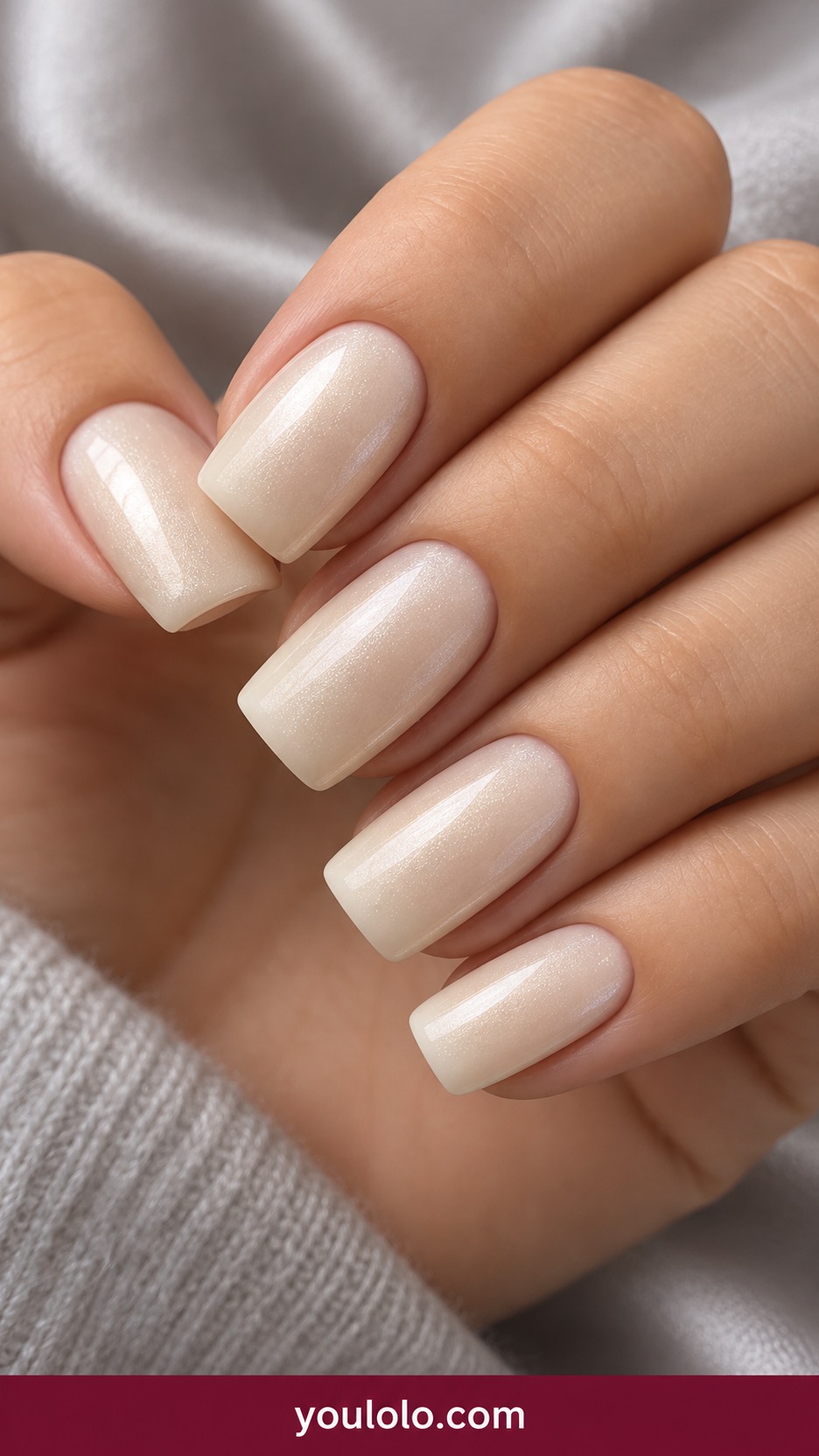 Medium squoval vanilla ivory nails with fine pearlescent sheen no mirror chrome on a naturally curled young adult hand