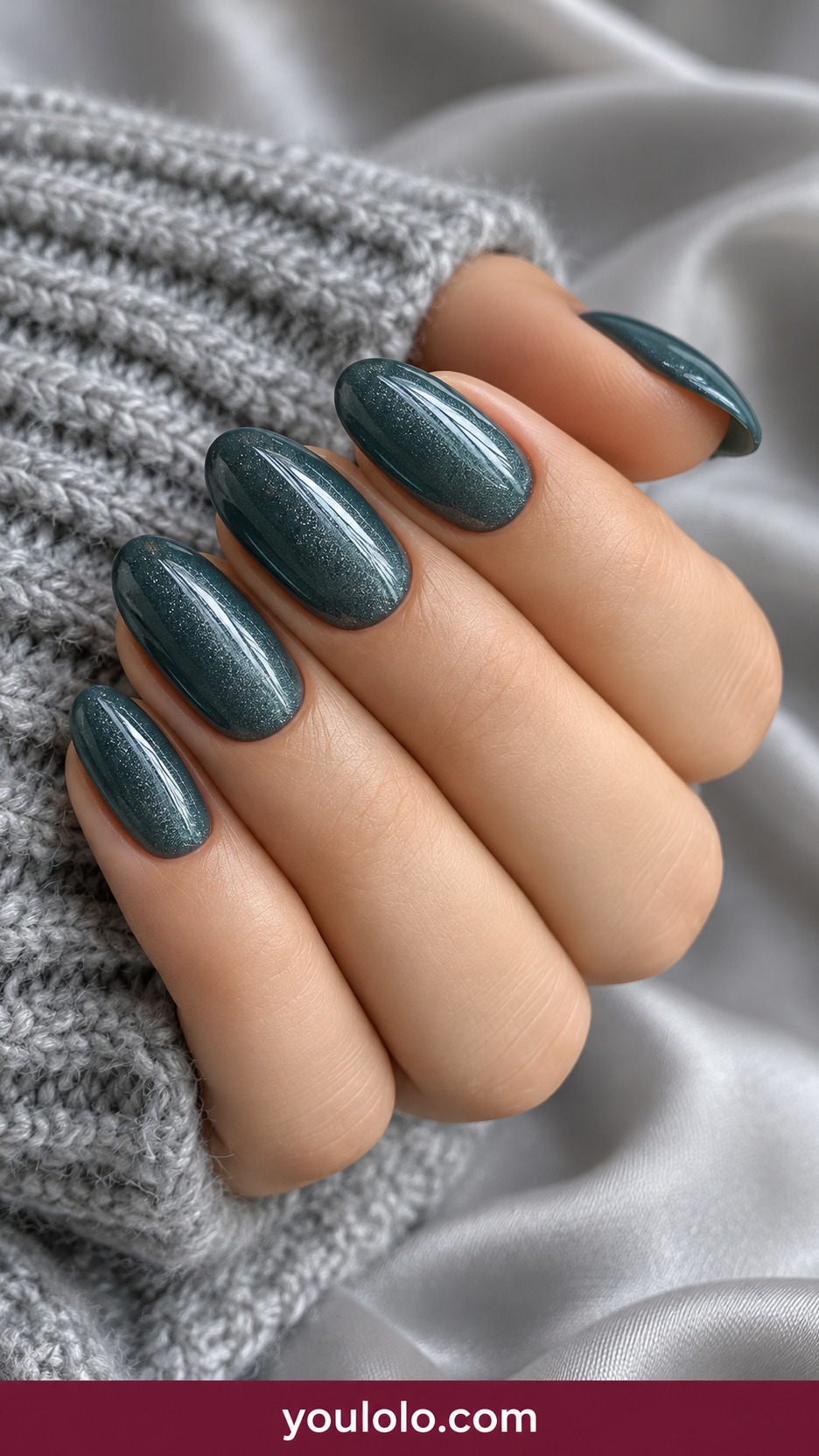 Short oval muted teal nails with fine silver shimmer uniform on a naturally curled young adult hand