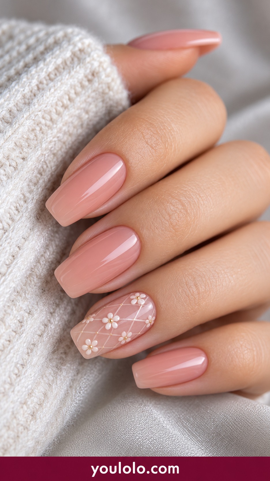 Medium square sheer nude nails one accent with fine ivory open lattice and tiny flat daisies, remaining nails pale peach pink on a naturally curled young adult hand