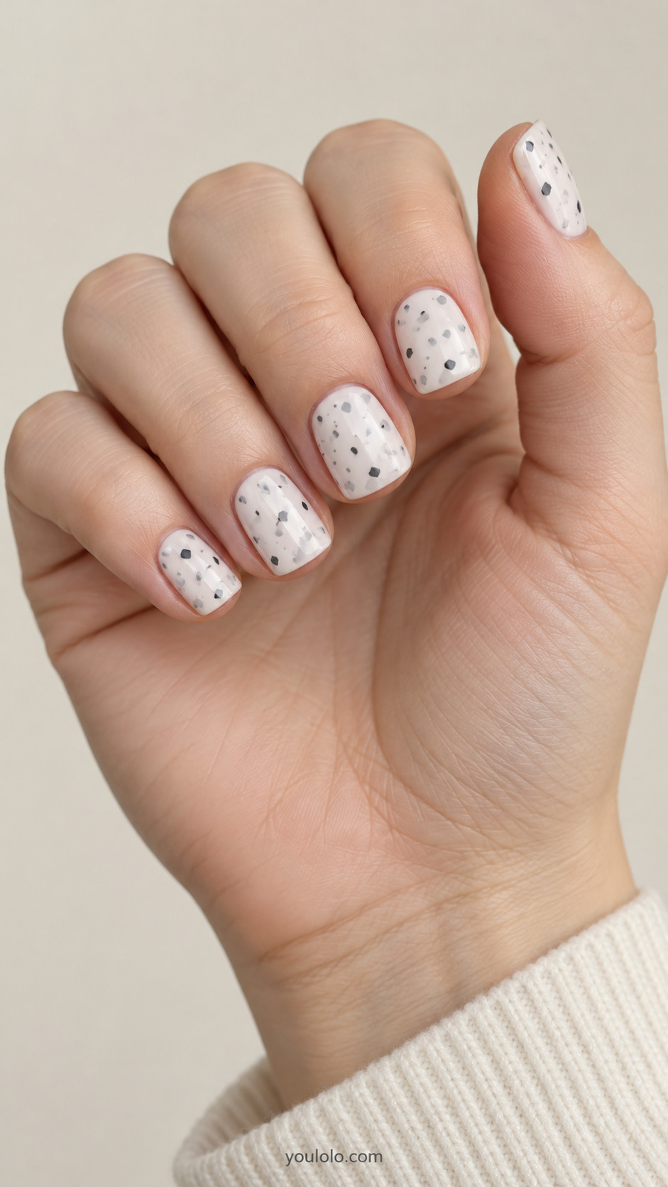 Short creamy white square nails with scattered irregular gray and charcoal flecks