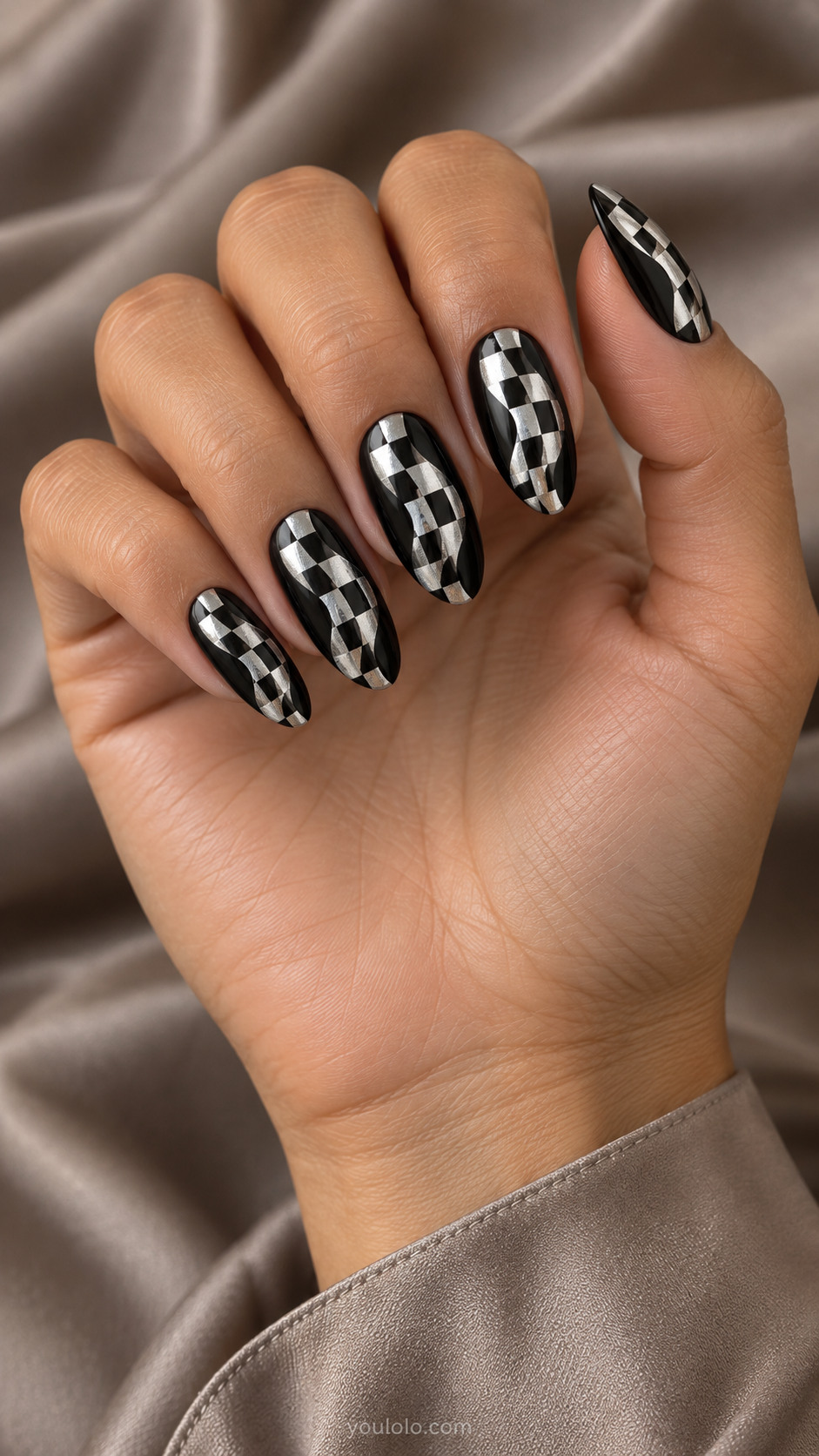 Medium almond nails black and mirror silver warped curved checker pattern only central band, black border at sides, fluid optical geometry