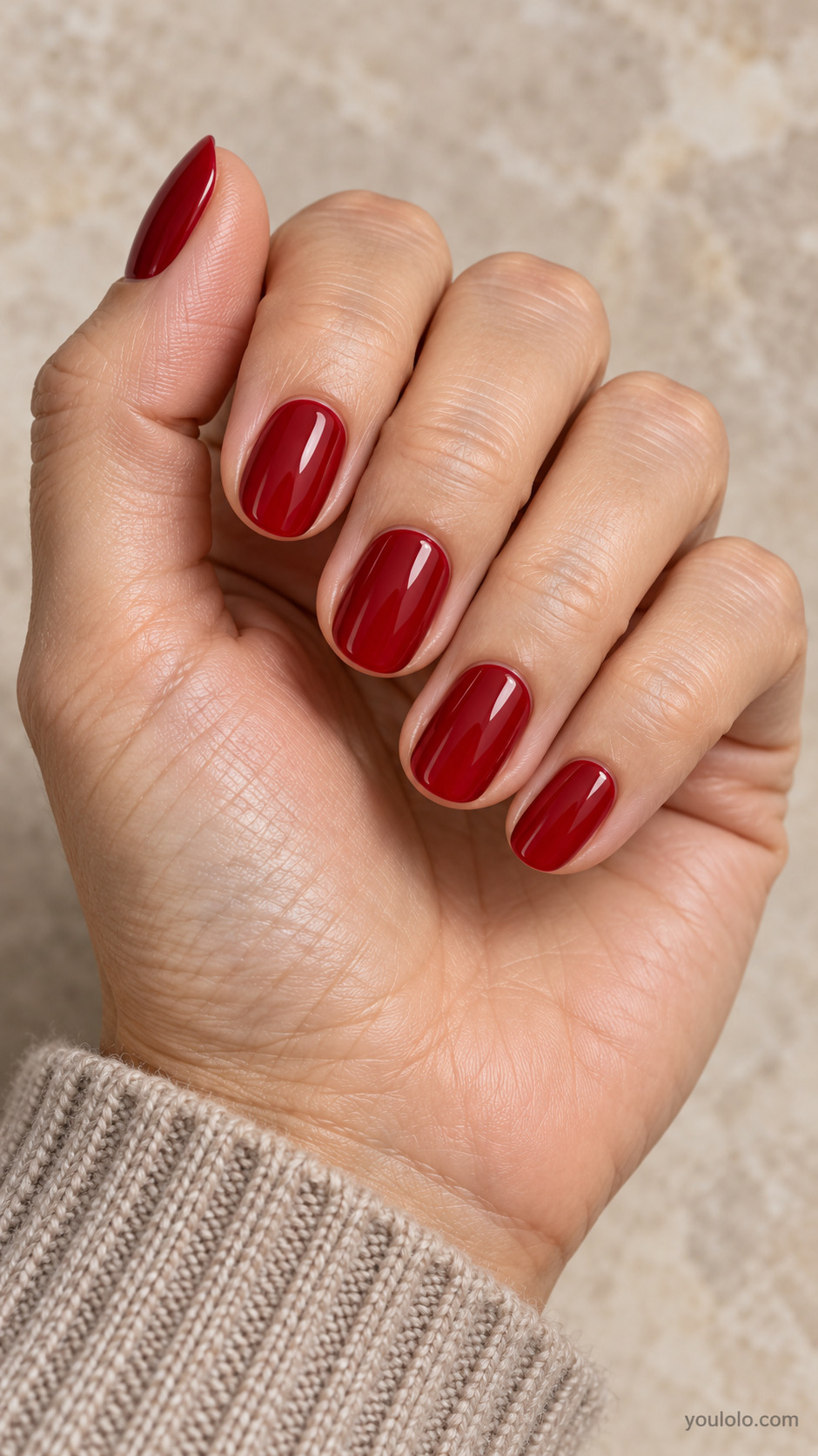 Short oval nails with a smooth glossy cherry red manicure.