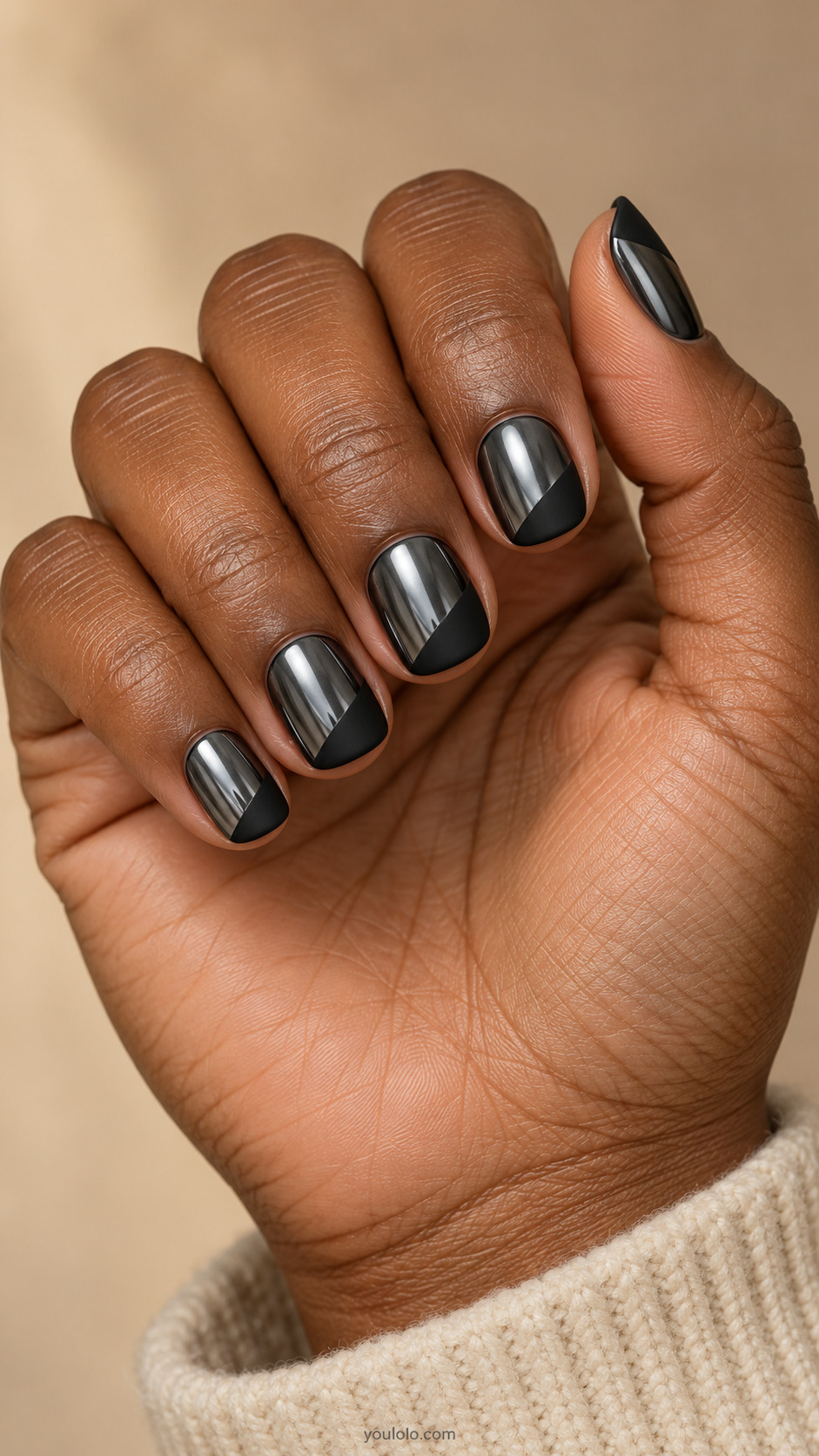 Short rounded-square nails with dark mirror chrome lower threequarters and one broad matte-black diagonal corner at tip, no stripe border
