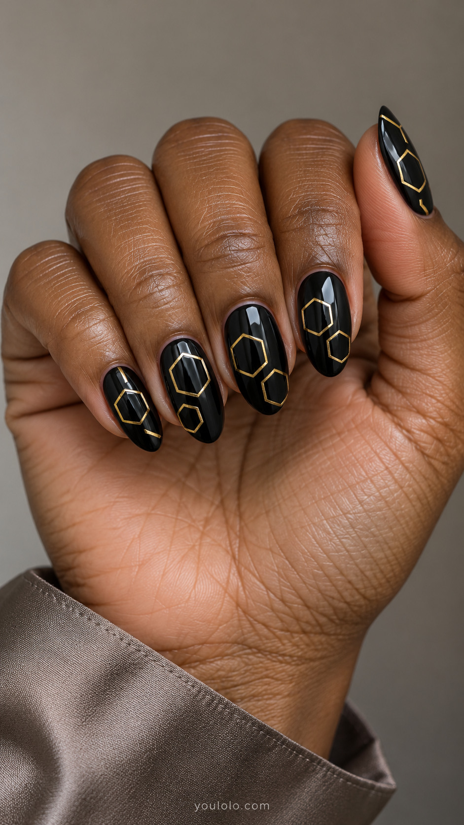 Black almond nails with staggered open gold hexagon outlines