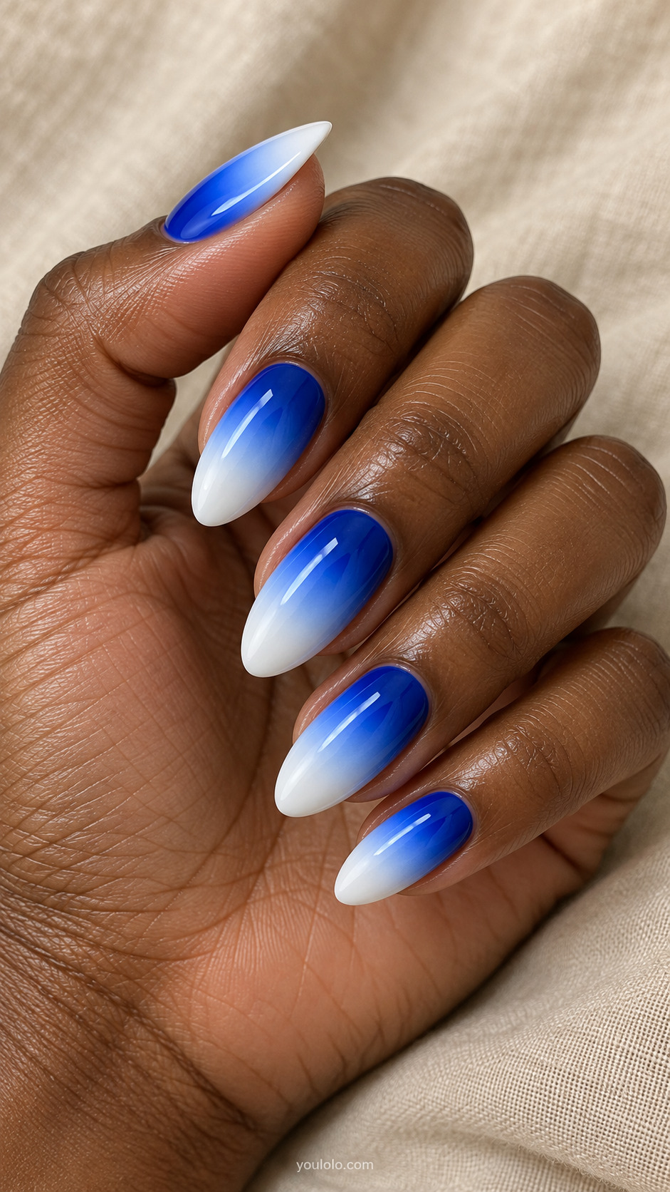 Almond nails fading from royal blue near the base to white tips