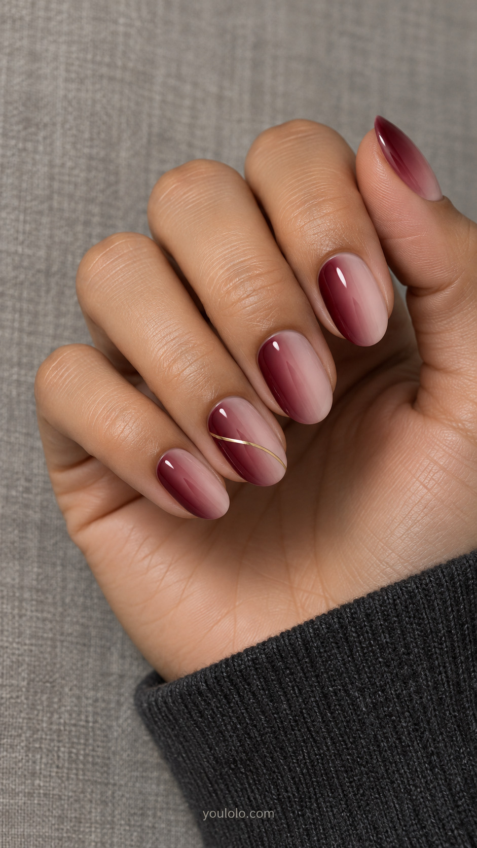 Oval nails with side-to-side burgundy fades and a fine gold curve