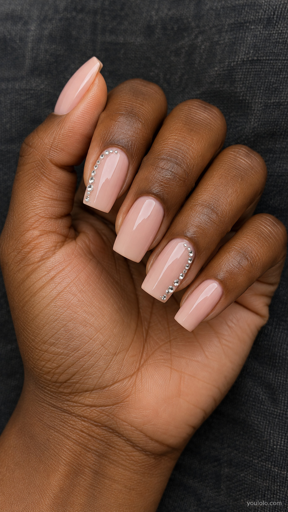 Long nude pink square nails with clear rhinestone borders on two nails
