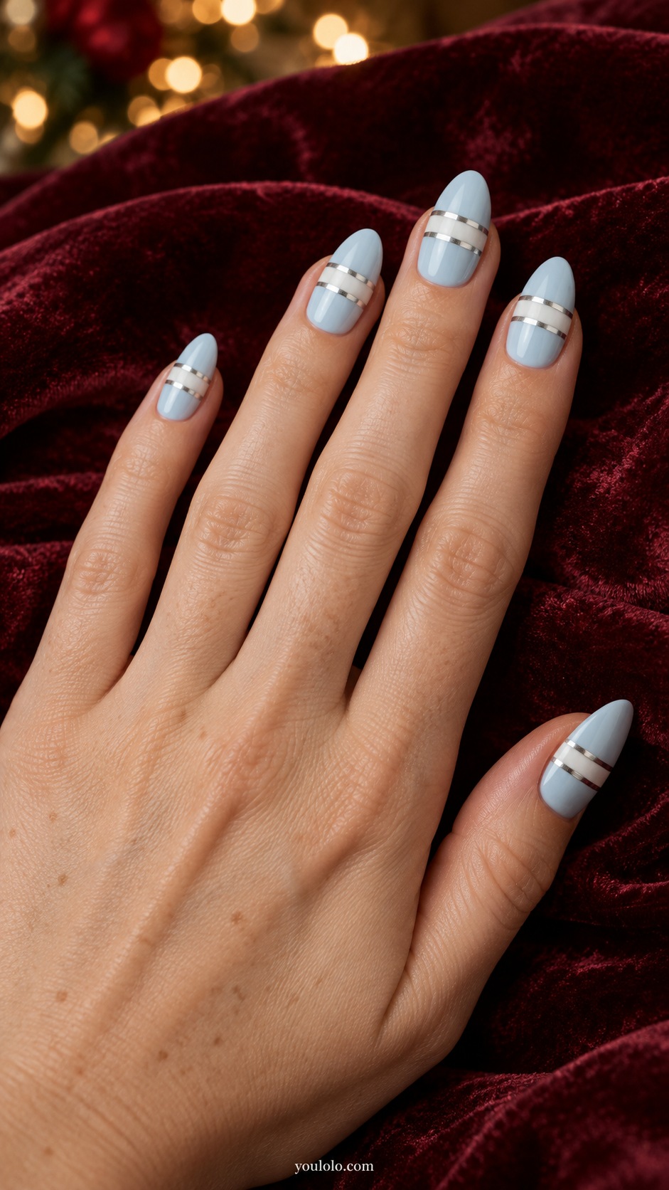 Medium almond pale ice blue nails two fine silver chrome transverse bands separated by a narrow white band