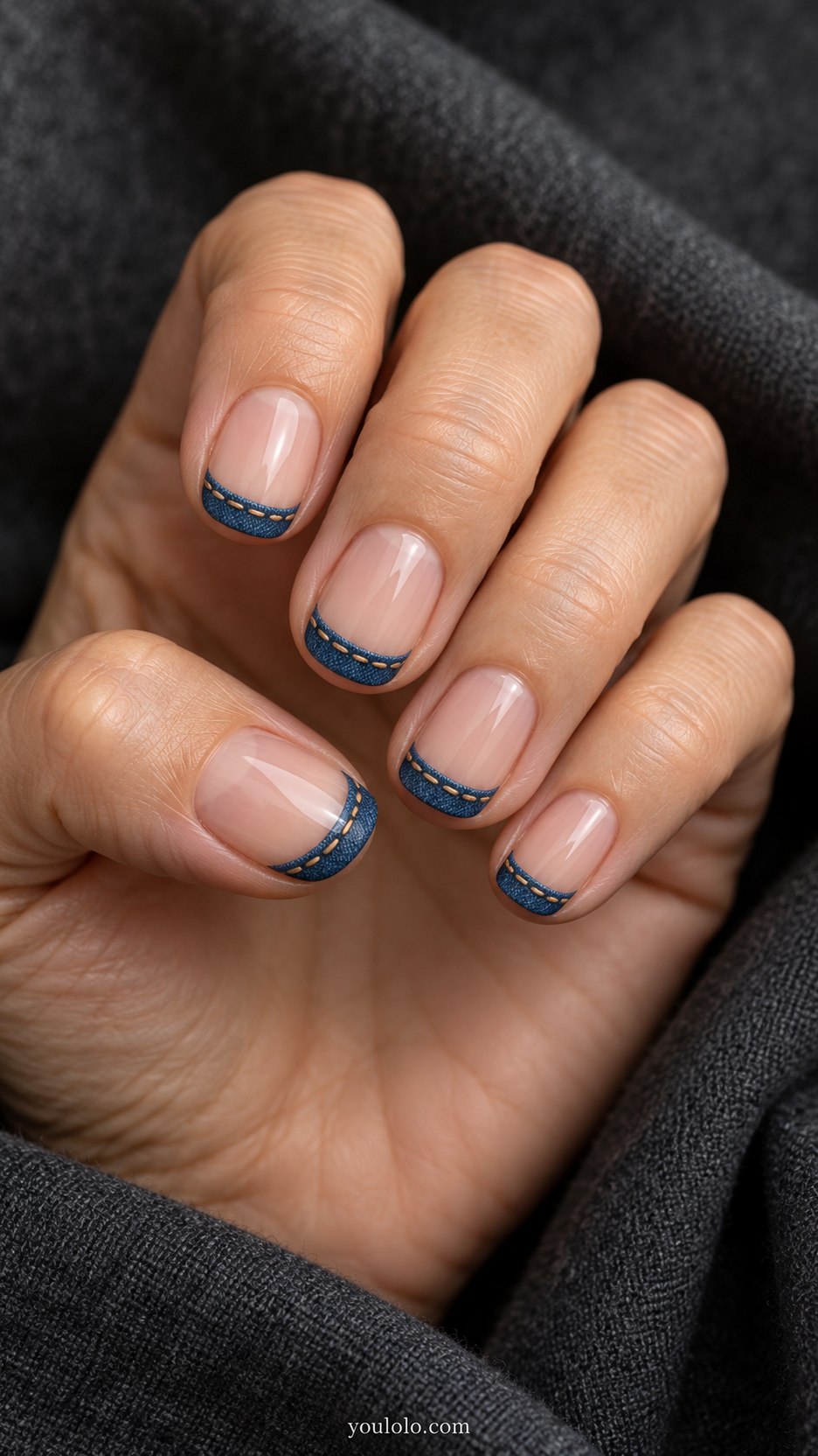 Minimal Blue Hemlines: short rounded sheer nude nails, narrow blue denim band across tip finished with fine tan dashed stitches