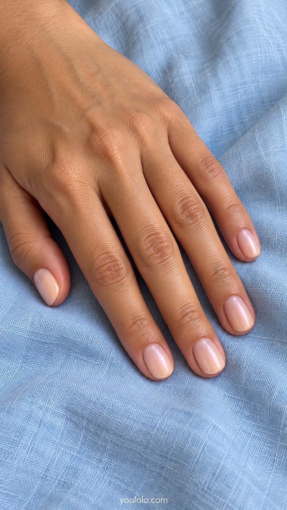 Short Wedding Nails: Soft Peach Pearl manicure on a naturally posed hand