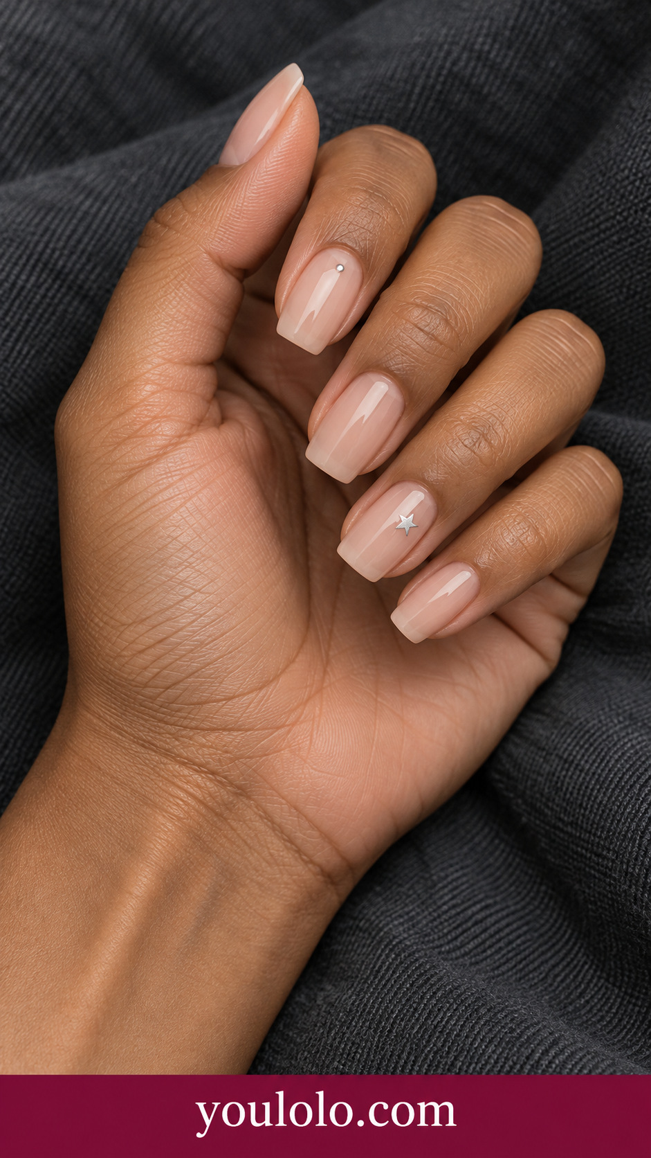 medium soft square sheer cool nude press-on nails one tiny flat painted silver star on ring nail and one tiny silver dot on index, others plain nude on a naturally posed adult female hand