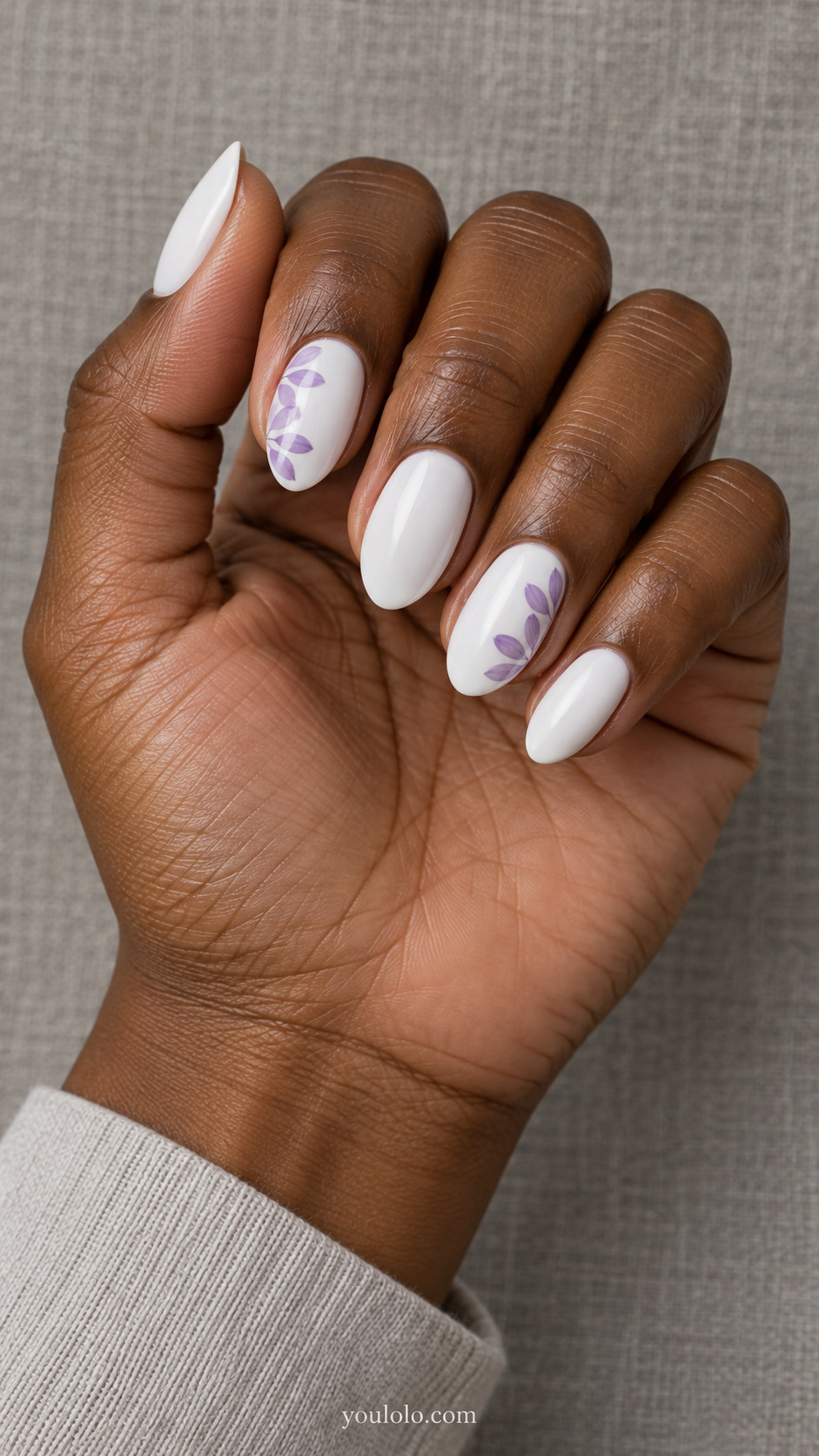 White almond nails with translucent lilac petals along two side edges