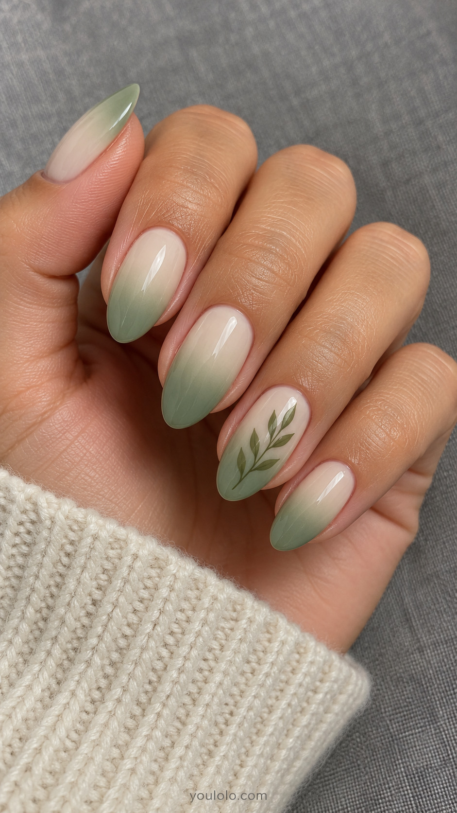Cream-to-sage almond nails with one tiny olive leaf sprig
