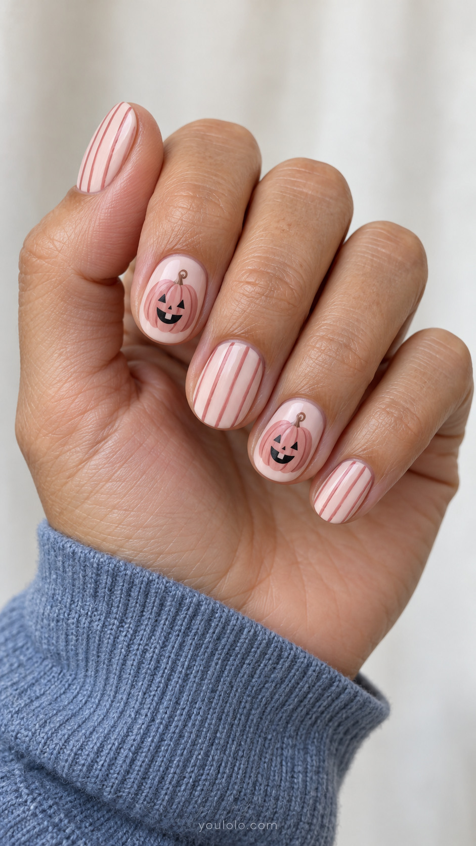 Short pink nails with rose jack-o-lantern faces and fine stripes