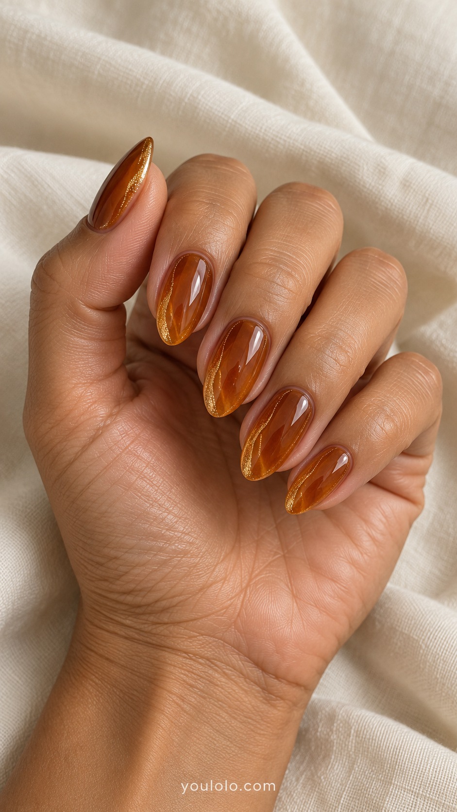 Medium almond nails transparent amber jelly with thin warm golden shimmer following one side each nail
