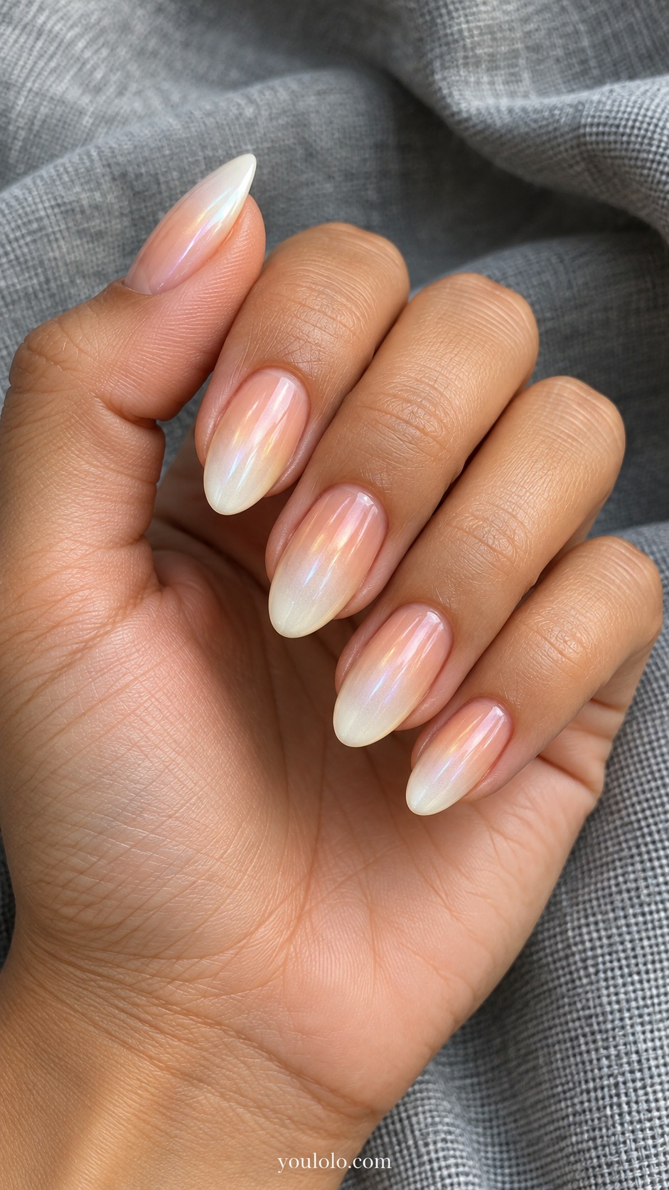Medium almond nails smooth gradient sheer peach at cuticle to pale ivory pearl tips, delicate pearlescent sheen, no beads