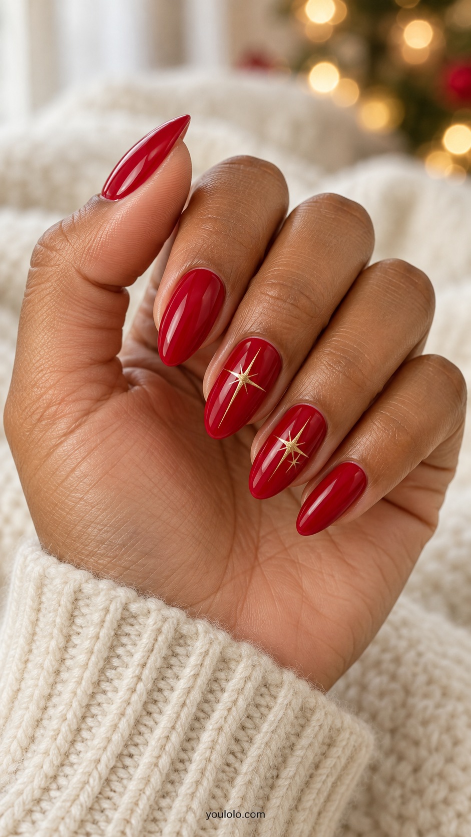 Medium almond glossy festive red nails thin painted gold elongated four point starbursts on two nails