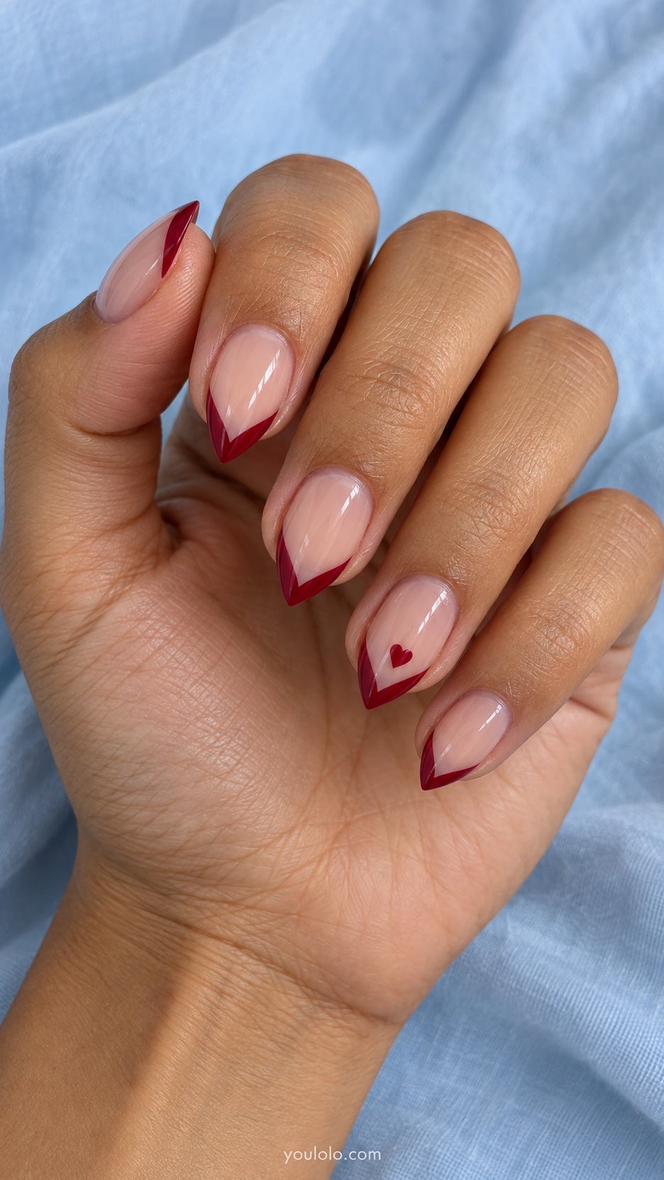 Short Stiletto French Nails: Ruby Micro Heart Tip manicure on a naturally posed hand