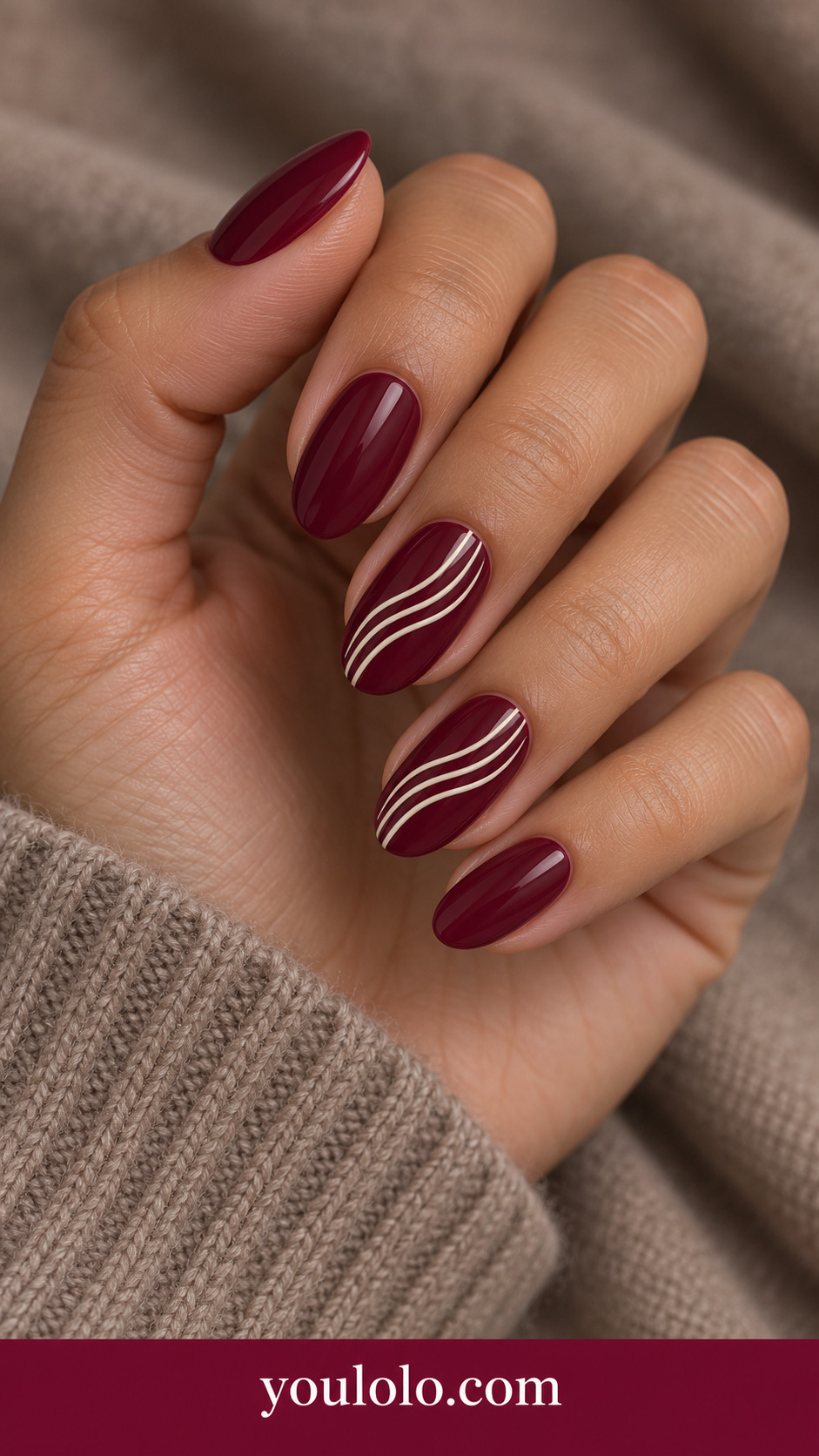 Wine Ivory Fine Waves: medium oval wine nails two accents three thin ivory parallel flowing waves diagonally across center on a naturally posed adult hand
