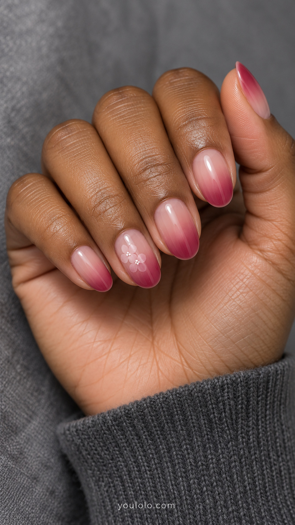 Blush-to-raspberry oval nails with two tiny pale pink flowers on one accent