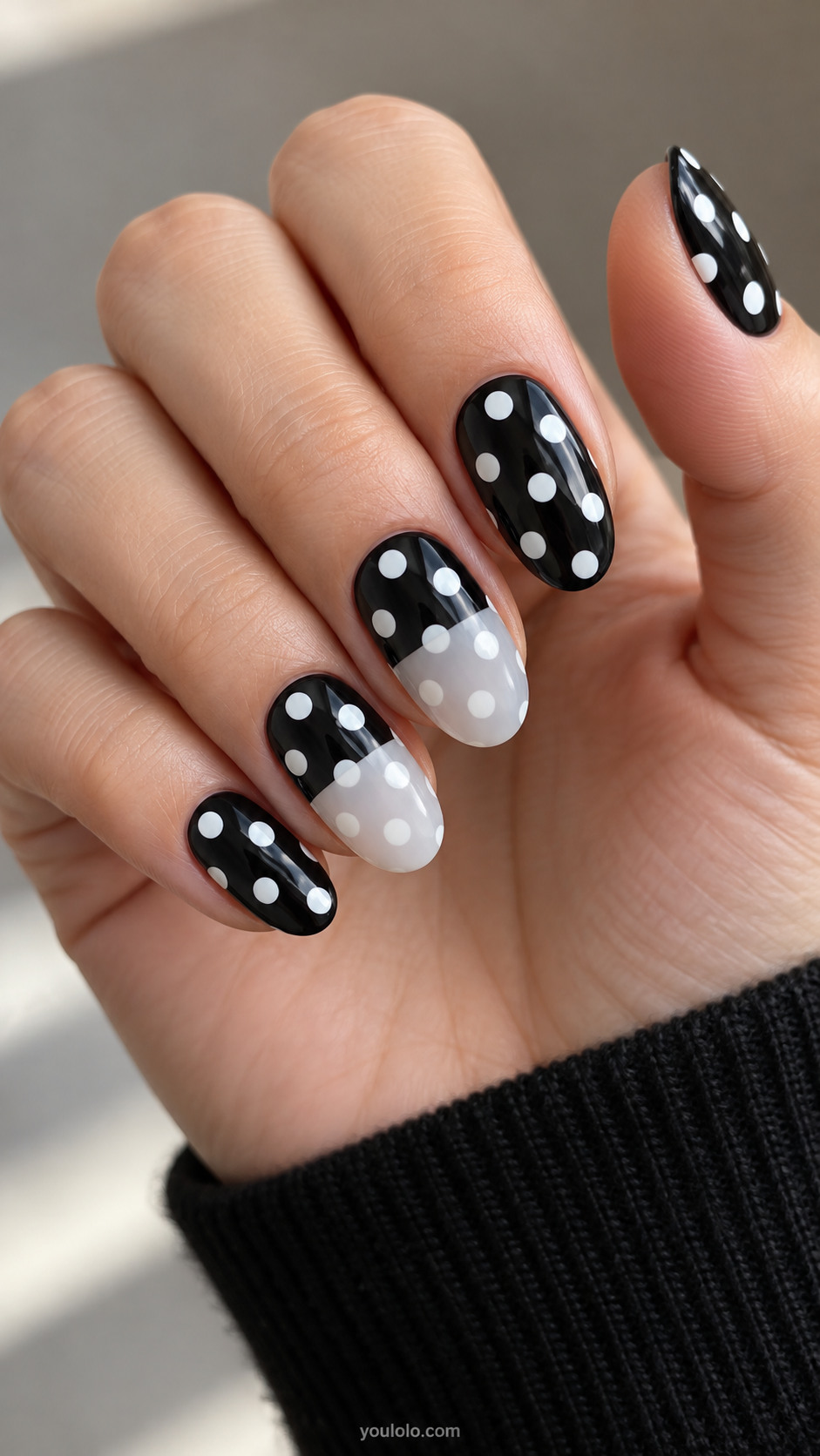 Medium oval nails black base with large white dots, middle and ring nails translucent milky white veil over lower half softening dots there with clear straight boundary