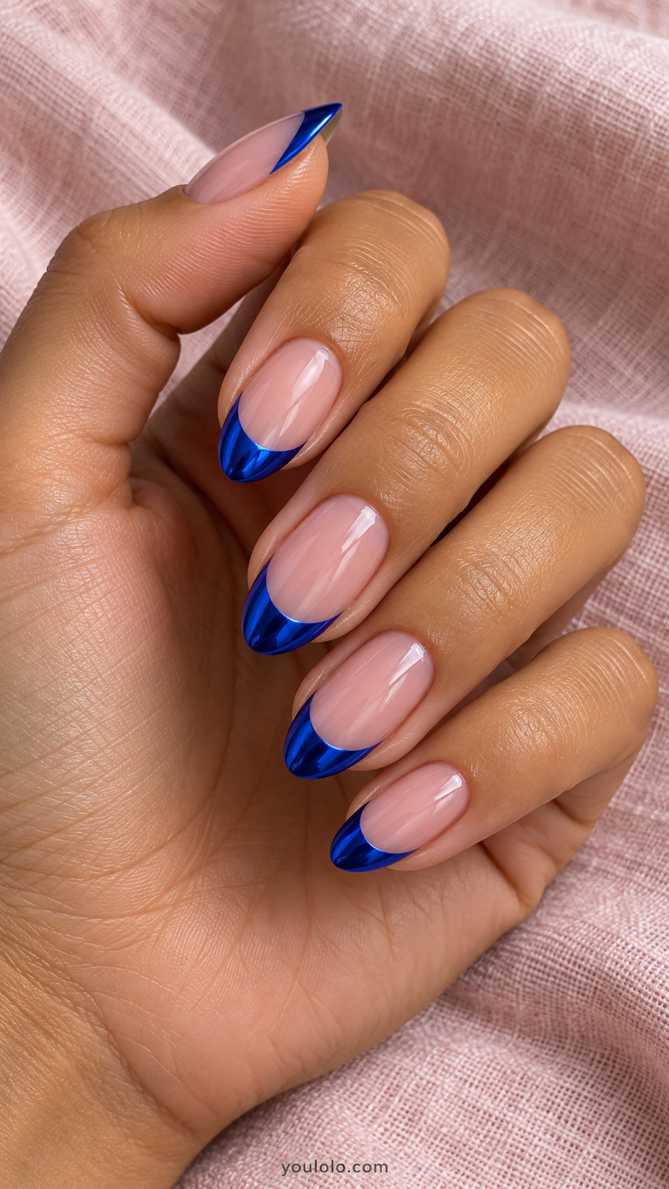 Nude pink almond nails with metallic royal blue French tips