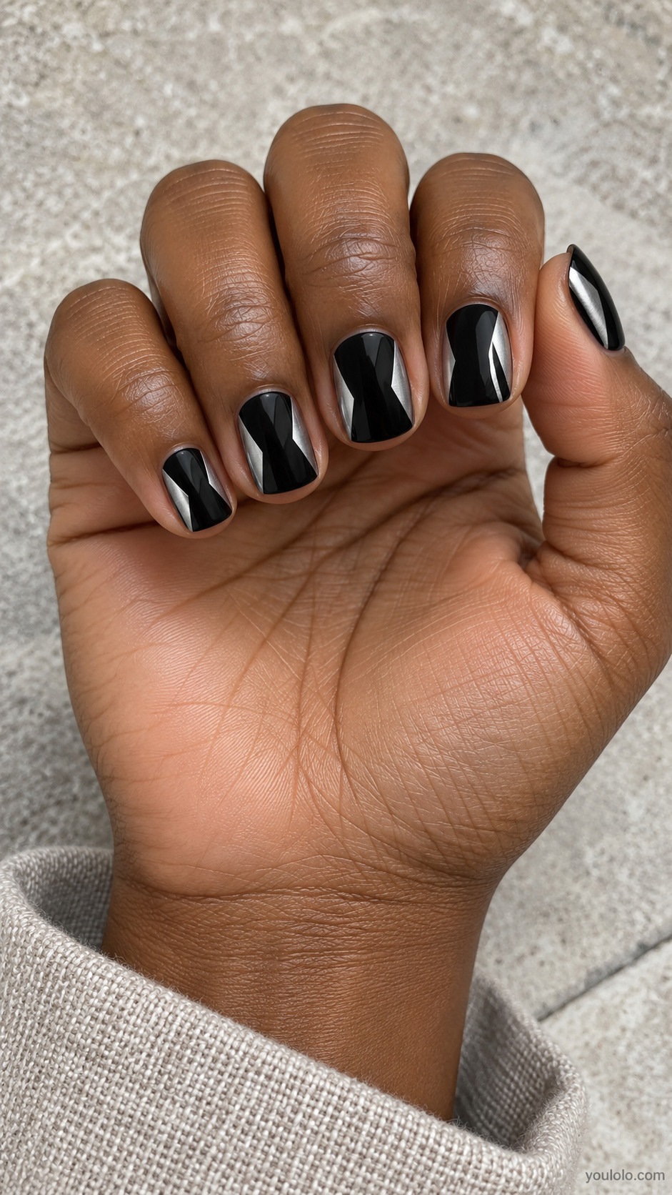 Short square black nails angular thin brushed silver triangle inlays arranged near each sidewall leaving broad black center, orderly architectural pattern