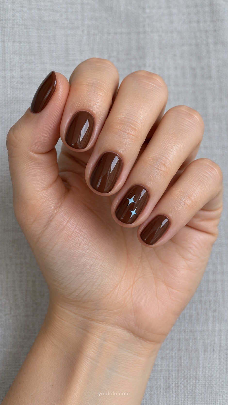Chocolate with Blue Stars — short oval chocolate nails one ring nail two tiny powder blue four point stars