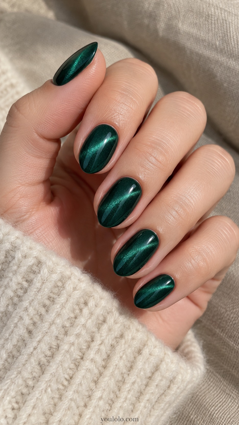 Short Almond Nail Designs: Emerald Satin Glow manicure on a naturally posed hand